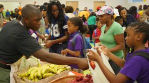 Volunteers help families choose produce; photo: KIPP DC