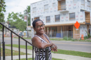 Woman stands in front of new construction