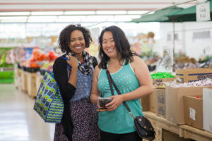 Two women smile in Ken'd Fruit Market