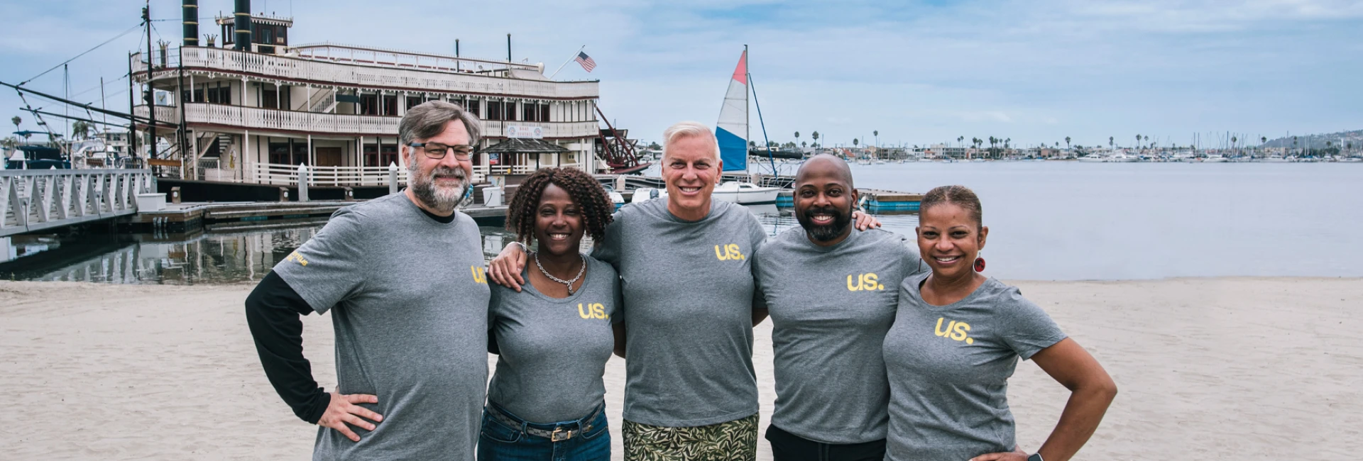 The Momentus Capital Capital Impact Partners Executive Management team gathers together at a company event, all wearing the same t-shirt and smiling.